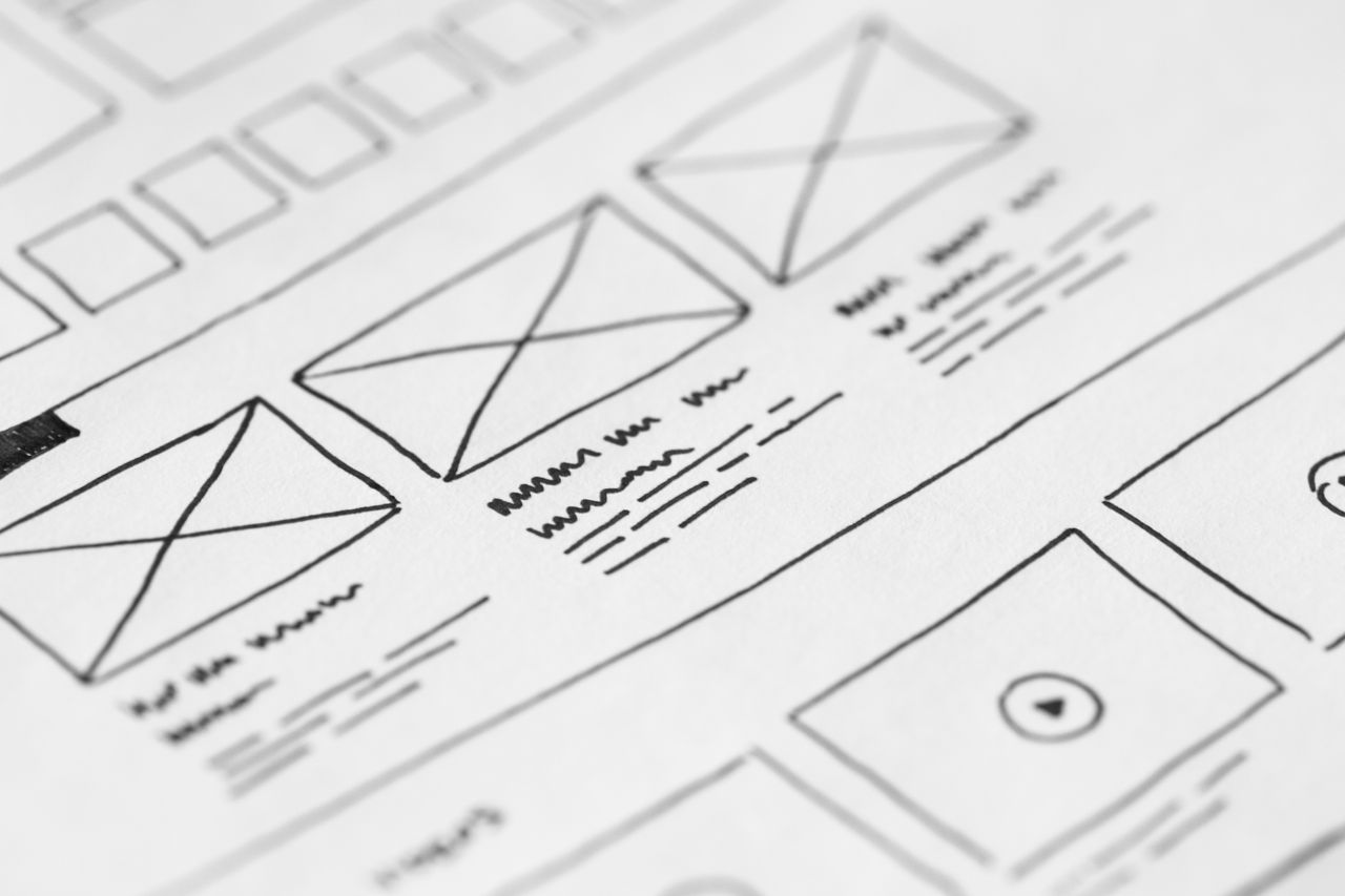 services-01 Detailed close-up of a hand-drawn wireframe sketch on paper for a UX project.